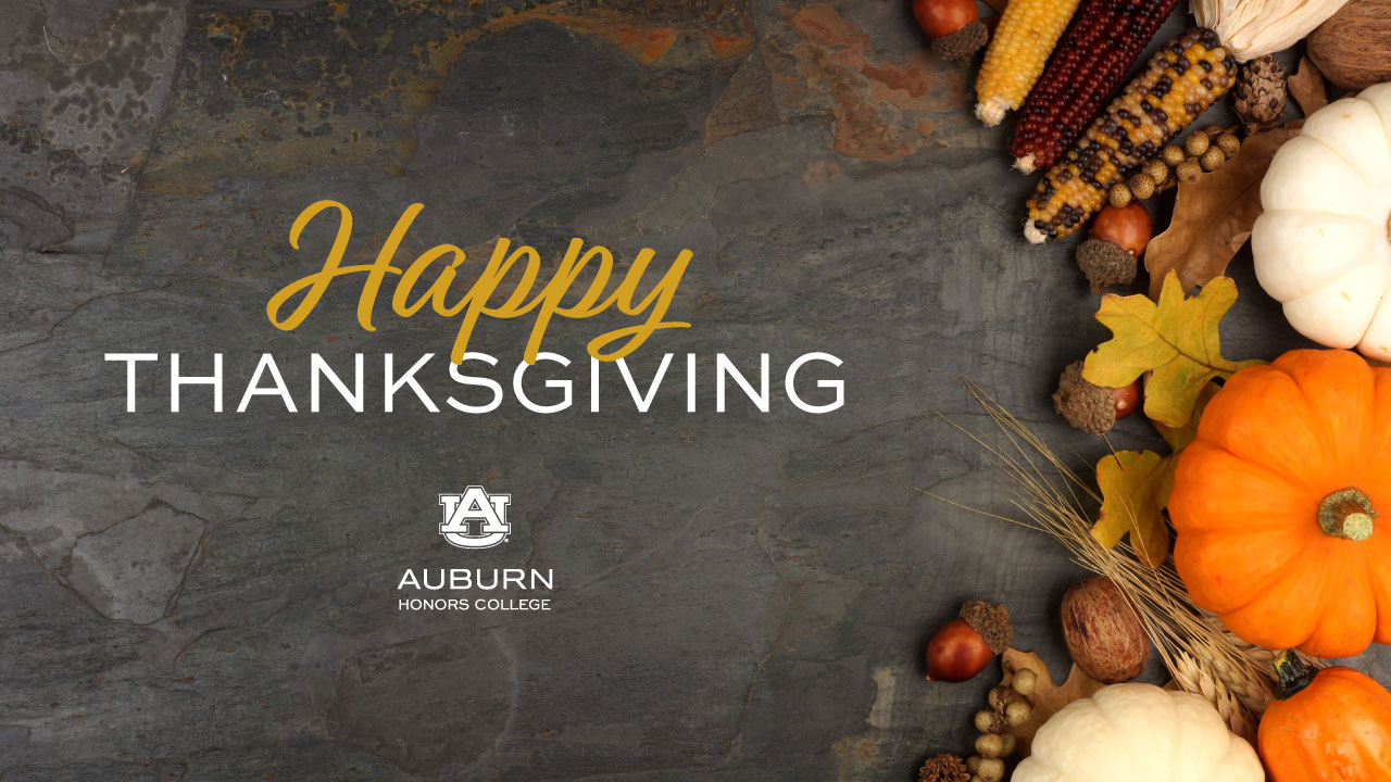 pumkins and squash sit on a slate background with the words: Happy thanksgiving on top